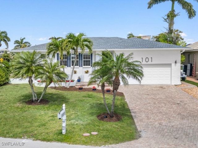 view of front of property featuring a front lawn and a garage