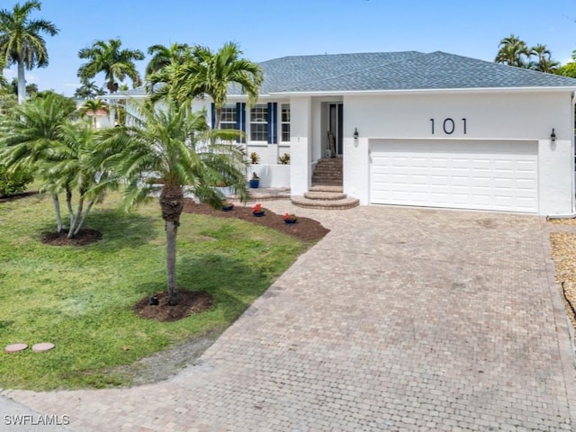 ranch-style home featuring a garage and a front lawn