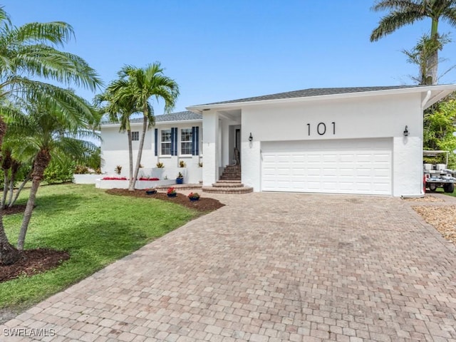 single story home featuring a front yard and a garage