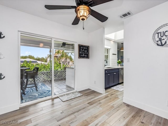 interior space with ceiling fan, sink, and light hardwood / wood-style floors