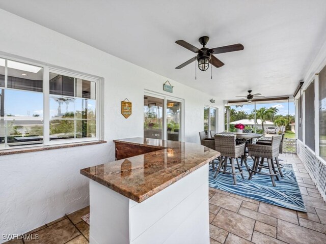 view of patio with ceiling fan and exterior bar