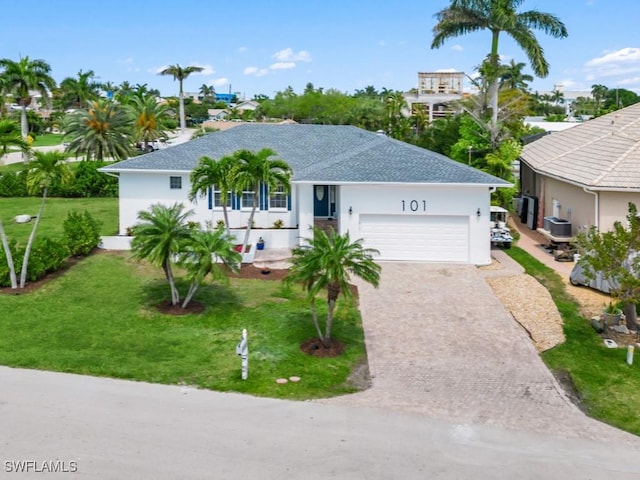 ranch-style home with cooling unit, a garage, and a front lawn