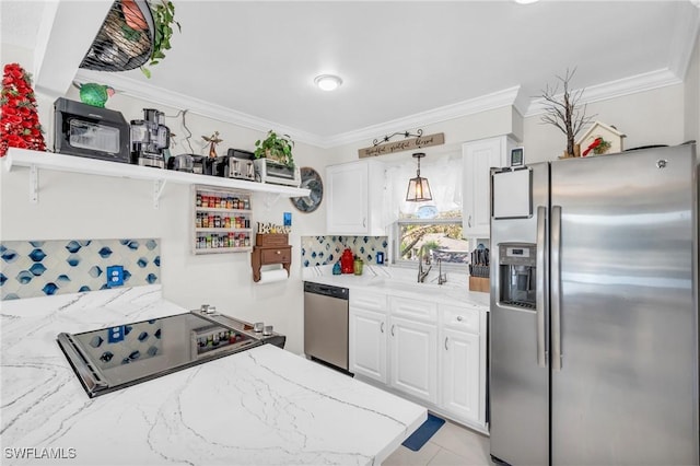 kitchen with appliances with stainless steel finishes, ornamental molding, sink, pendant lighting, and white cabinetry