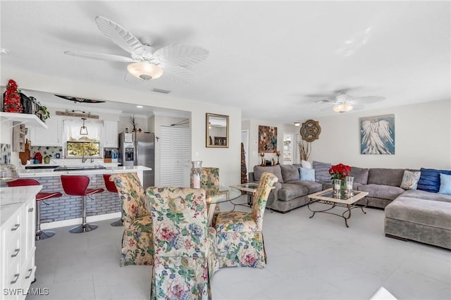 living room with ceiling fan and crown molding