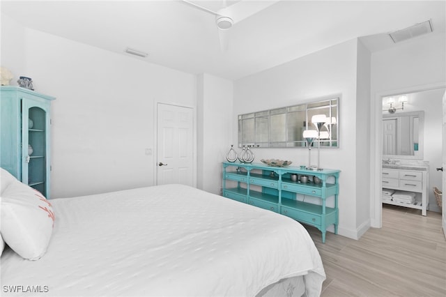 bedroom with ceiling fan, sink, connected bathroom, and light wood-type flooring