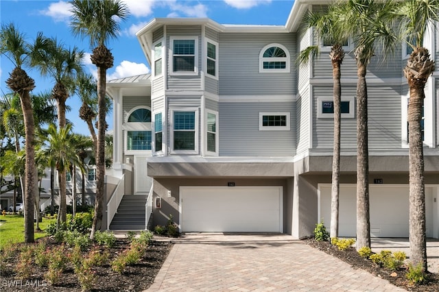 160 Barefoot Cir Unit 38, Bonita Springs, FL 34134 - view of front of property with a standing seam roof, an attached garage, stucco siding, and decorative driveway