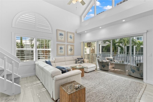 living room featuring ceiling fan and high vaulted ceiling