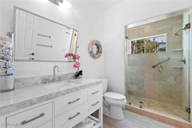 160 Barefoot Cir Unit 38, Bonita Springs, FL 34134 - bathroom with vanity, wood finished floors, toilet, and a shower stall