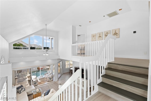 160 Barefoot Cir Unit 38, Bonita Springs, FL 34134 - staircase with baseboards, high vaulted ceiling, visible vents, and wood finished floors