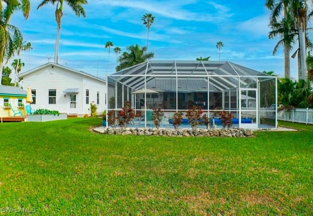 back of property with a yard and a lanai