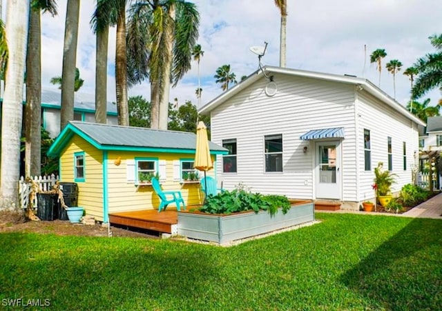 rear view of property featuring a yard and a deck