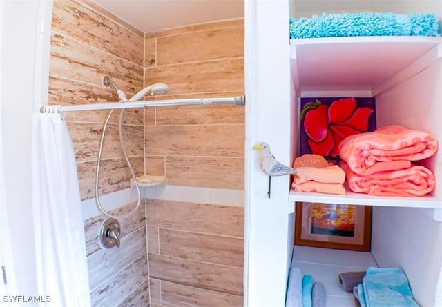 bathroom with wood walls and a shower with shower curtain