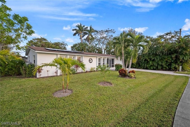 single story home with solar panels and a front yard