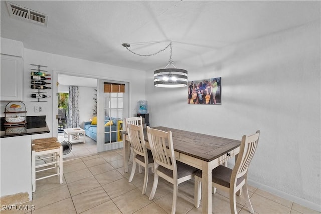 dining space featuring light tile patterned floors and a chandelier