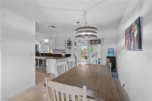 tiled dining space with sink and an inviting chandelier