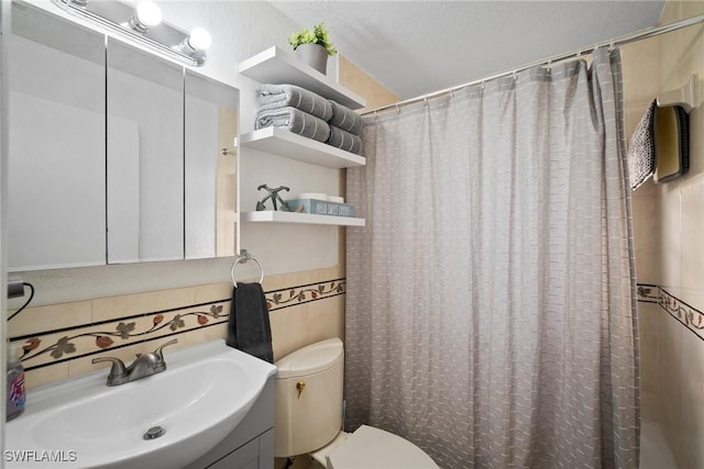 bathroom featuring a shower with shower curtain, vanity, toilet, and tile walls