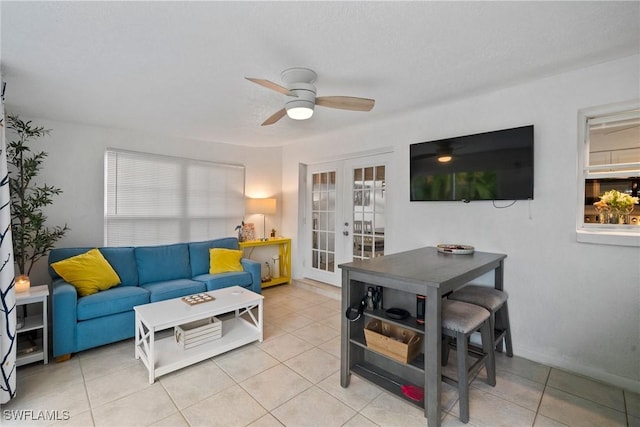 tiled living room featuring french doors and ceiling fan