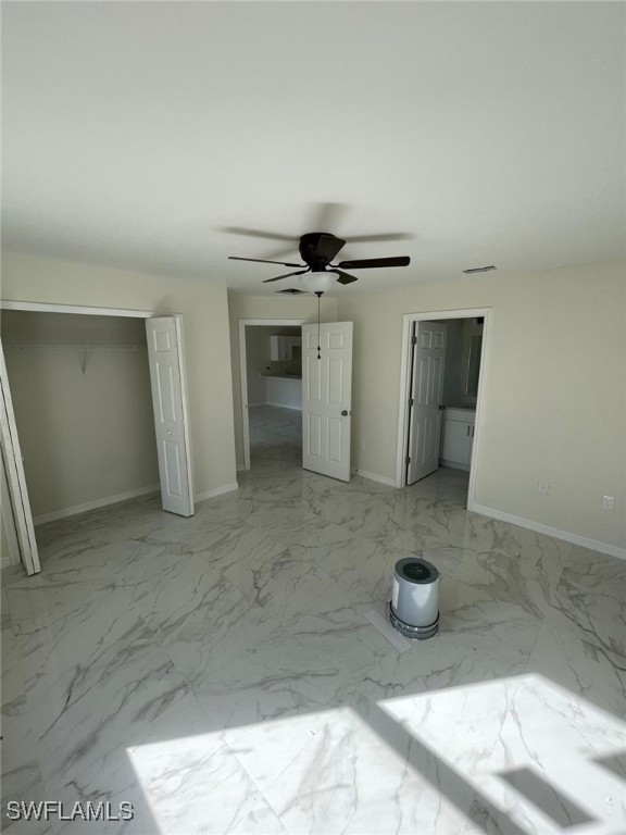 unfurnished bedroom with ceiling fan and a closet