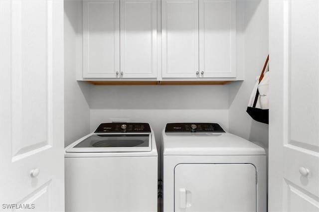 washroom with washer and clothes dryer and cabinets