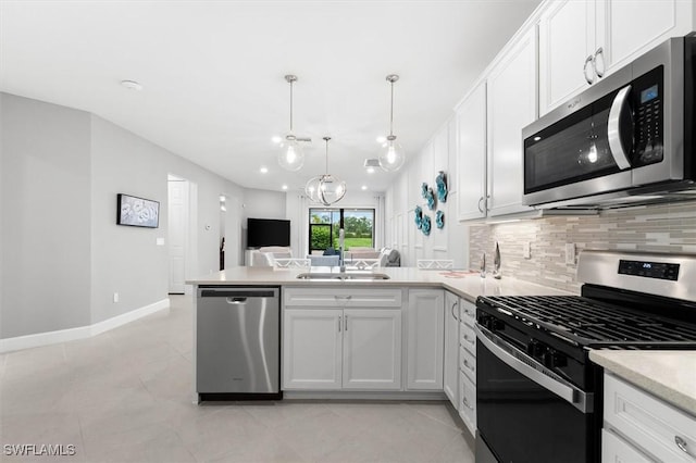 kitchen featuring appliances with stainless steel finishes, decorative light fixtures, white cabinetry, and sink