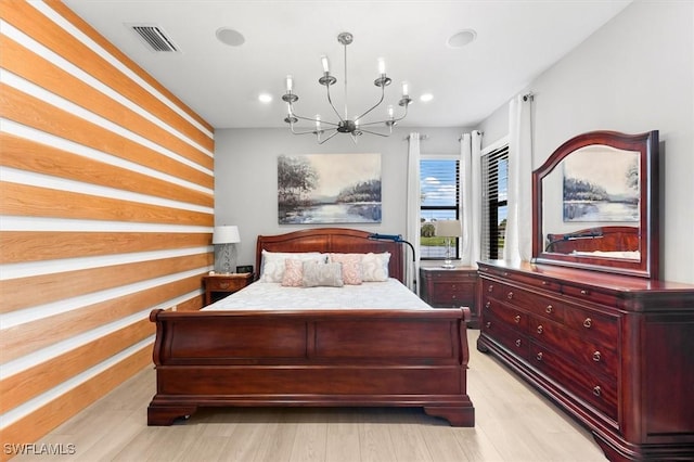 bedroom with an inviting chandelier and light hardwood / wood-style flooring