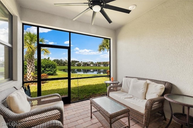 sunroom / solarium featuring a water view and ceiling fan