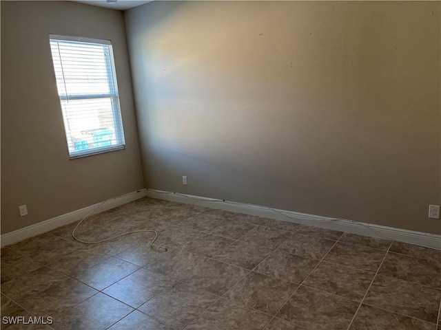 unfurnished room featuring dark tile patterned floors