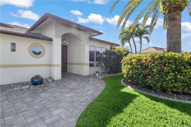 doorway to property with a lawn