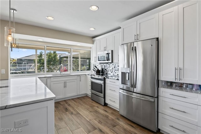 kitchen featuring sink, stainless steel appliances, tasteful backsplash, dark hardwood / wood-style flooring, and white cabinets