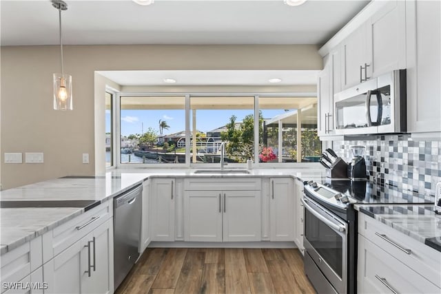 kitchen with light stone counters, stainless steel appliances, sink, dark hardwood / wood-style floors, and white cabinetry