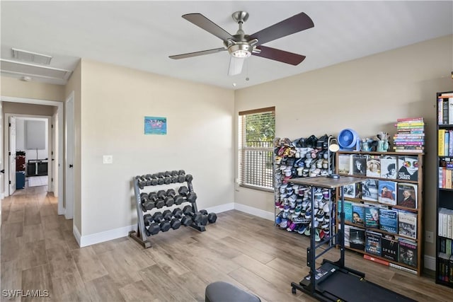 workout area featuring ceiling fan and light hardwood / wood-style floors