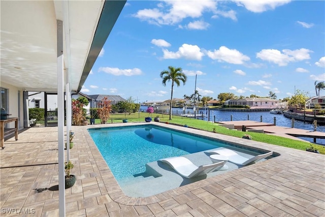 view of pool with a yard, a patio, a water view, and a dock