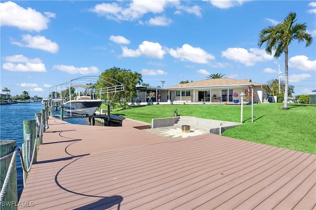 wooden terrace featuring a boat dock, a yard, and a water view