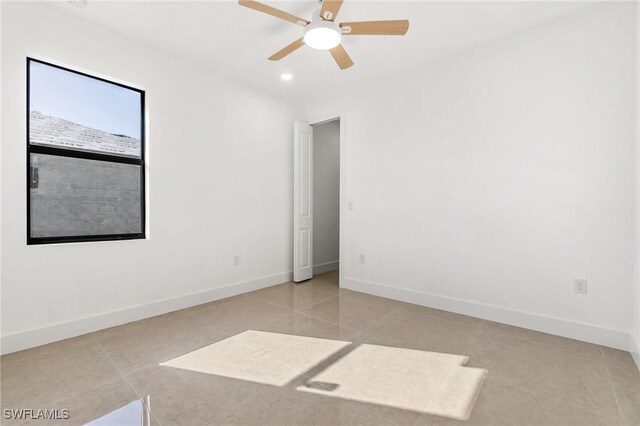 unfurnished room with ceiling fan and light tile patterned floors