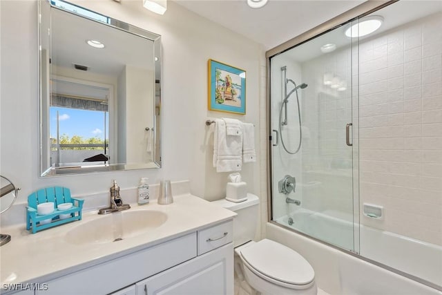 full bathroom with vanity, toilet, and enclosed tub / shower combo