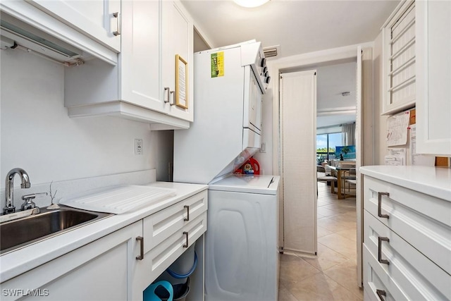 clothes washing area featuring stacked washer / dryer, sink, and light tile patterned floors