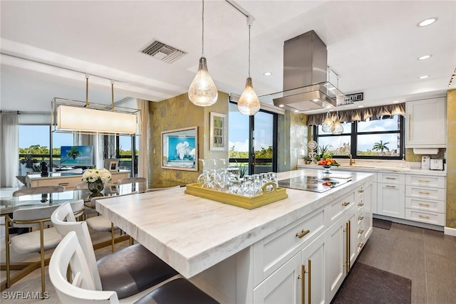 kitchen featuring black electric stovetop, a center island, white cabinetry, and island exhaust hood