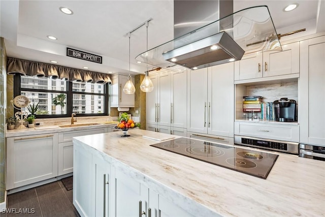 kitchen with stainless steel oven, sink, black electric cooktop, island range hood, and light stone counters