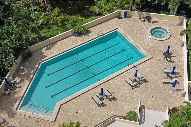 view of swimming pool featuring a hot tub