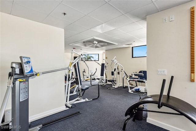 exercise room with a paneled ceiling and ceiling fan