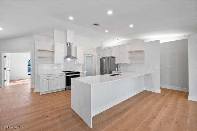 kitchen featuring white cabinets, appliances with stainless steel finishes, wall chimney exhaust hood, backsplash, and vaulted ceiling