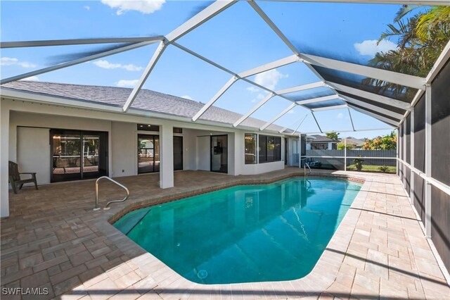 view of pool featuring glass enclosure and a patio