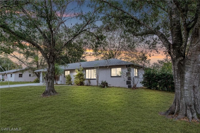 ranch-style home with a lawn