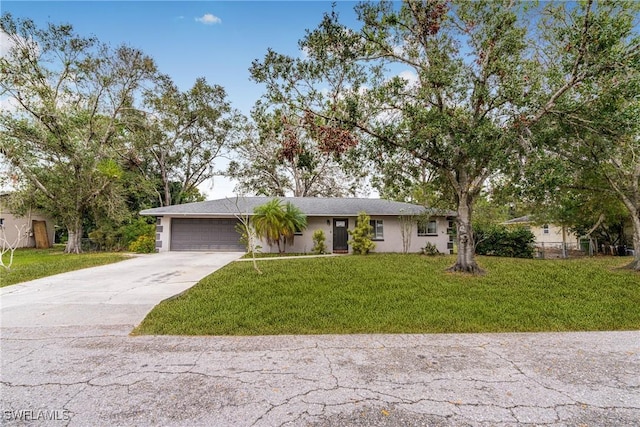 ranch-style house featuring a garage and a front lawn