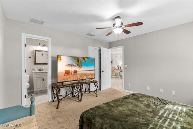 bedroom with connected bathroom, ceiling fan, light hardwood / wood-style flooring, and sink