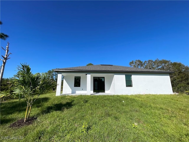 rear view of property with a lawn