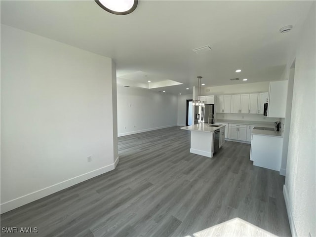 kitchen with sink, pendant lighting, a center island with sink, white cabinets, and hardwood / wood-style floors