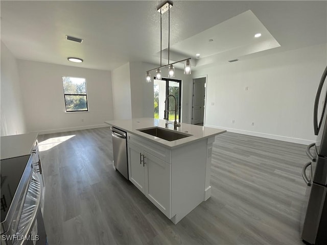 kitchen featuring white cabinets, a center island with sink, sink, stainless steel dishwasher, and dark hardwood / wood-style flooring