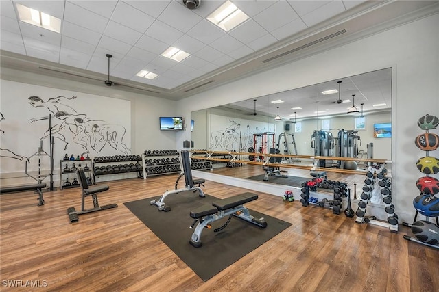 workout area featuring hardwood / wood-style flooring and ornamental molding