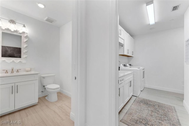 bathroom featuring vanity, toilet, and independent washer and dryer